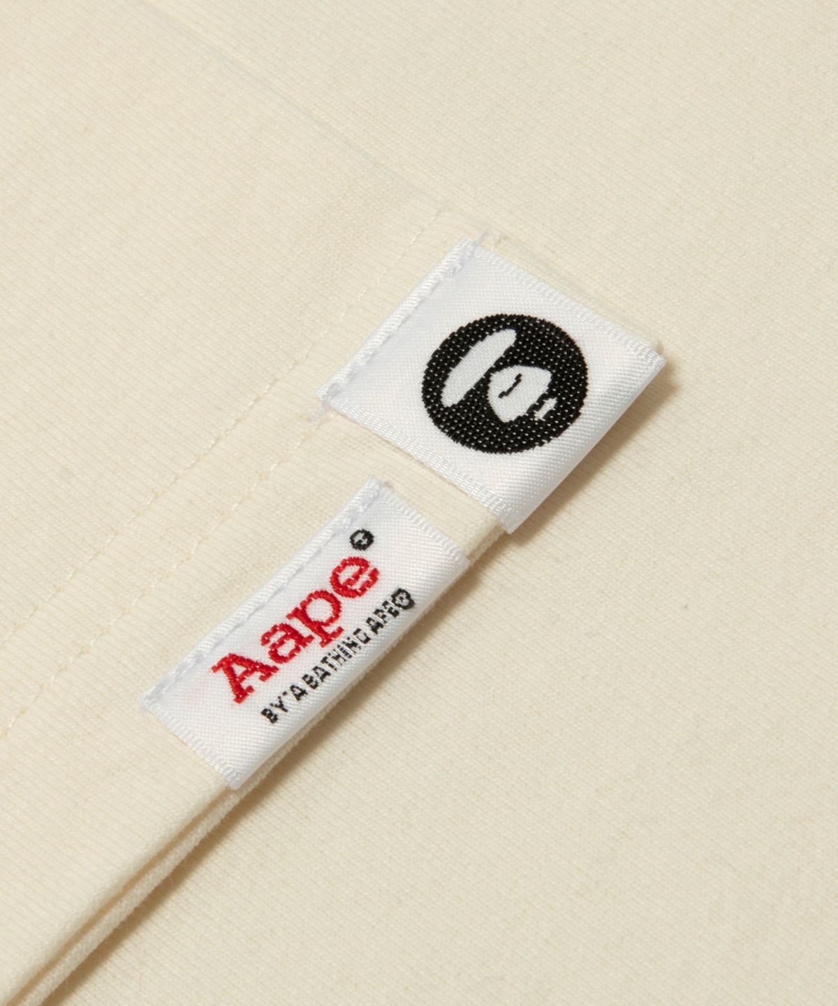 에이프(AAPE) 로고 그래픽 티셔츠 아이보리 / AAPTEW1905XXQIVX