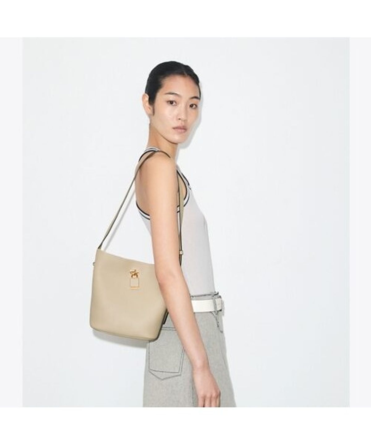토리버치(TORYBURCH) 락 슬림 미디엄 버킷백 - 라이트 스톤
