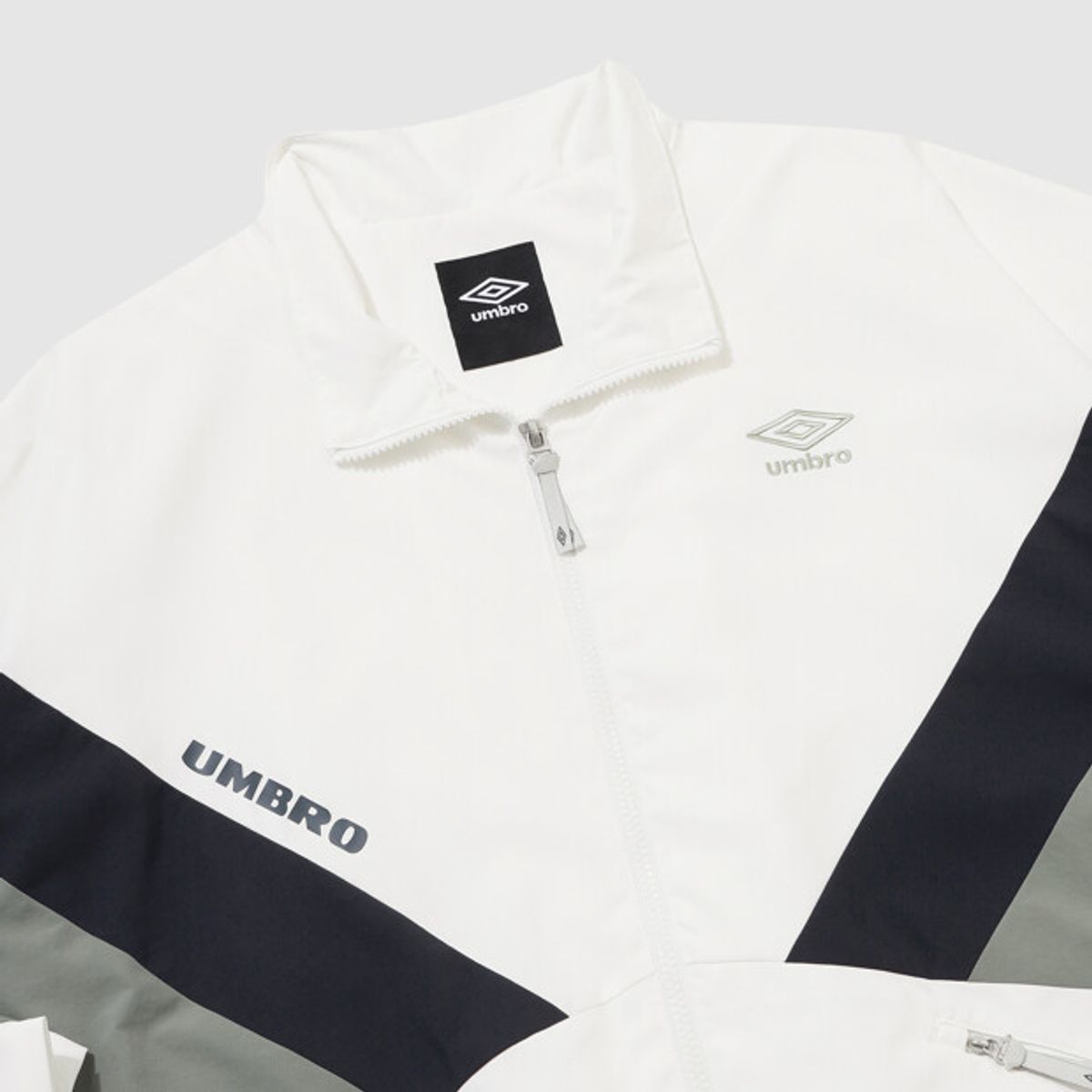 엄브로(UMBRO) 더비클럽 컬러블럭 스탠넥 바람막이 자켓 아이보리 UR324CJK94