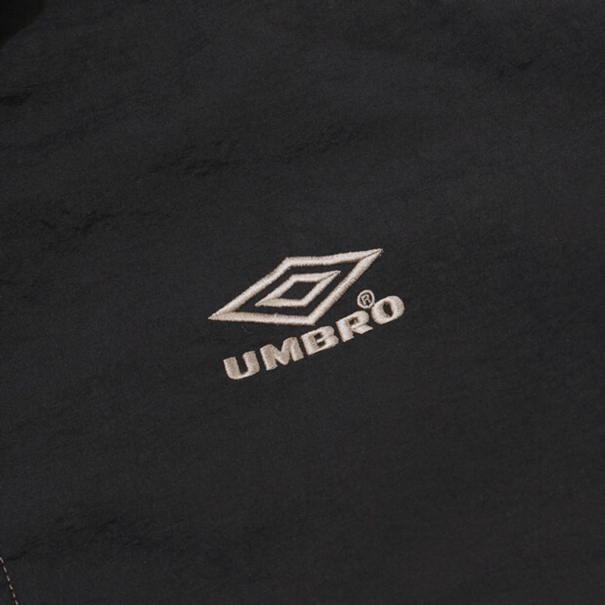 엄브로(UMBRO) 크리스피 타슬란 스탠넥 패딩 자켓 블랙 UR321CPJ91