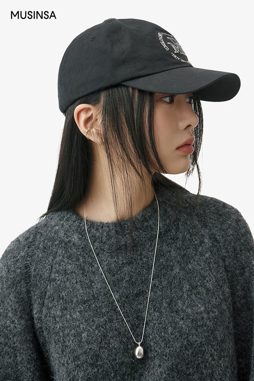 무톤 재킷과 슬릿 스커트의 조합에 볼캡, 스니커즈까지 블랙 컬러로 통일한 캐주얼 룩 #레터링 #오버핏 #올블랙 #모노톤 #겨울 #캐주얼 #무스탕