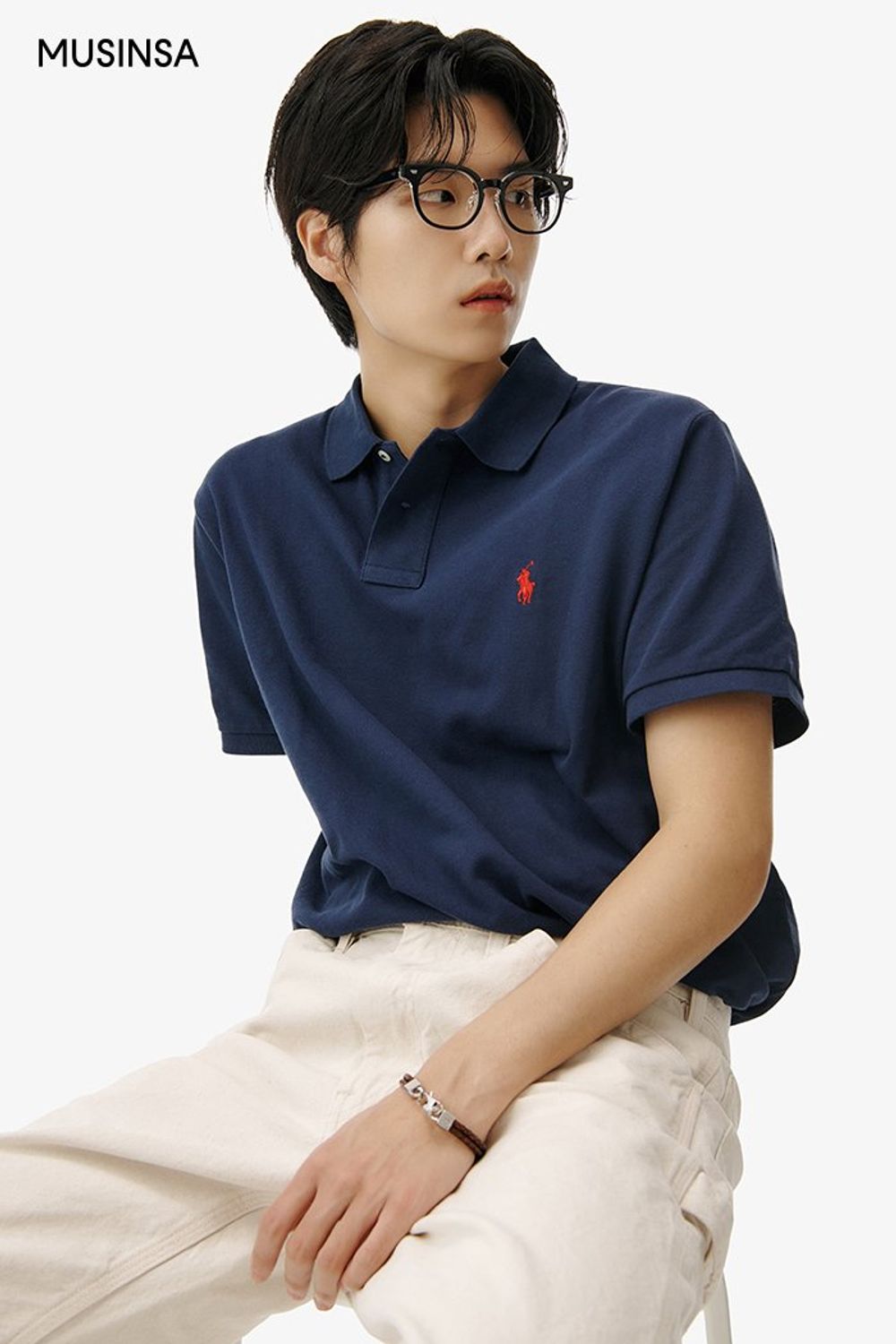 심벌이 돋보이는 피케 셔츠에 크림 컬러 팬츠를 코디한 댄디 룩 #캠퍼스 #남친룩 #심볼 #여름 #댄디 #가죽팔찌 #카라티코디 #에디터_이윤화