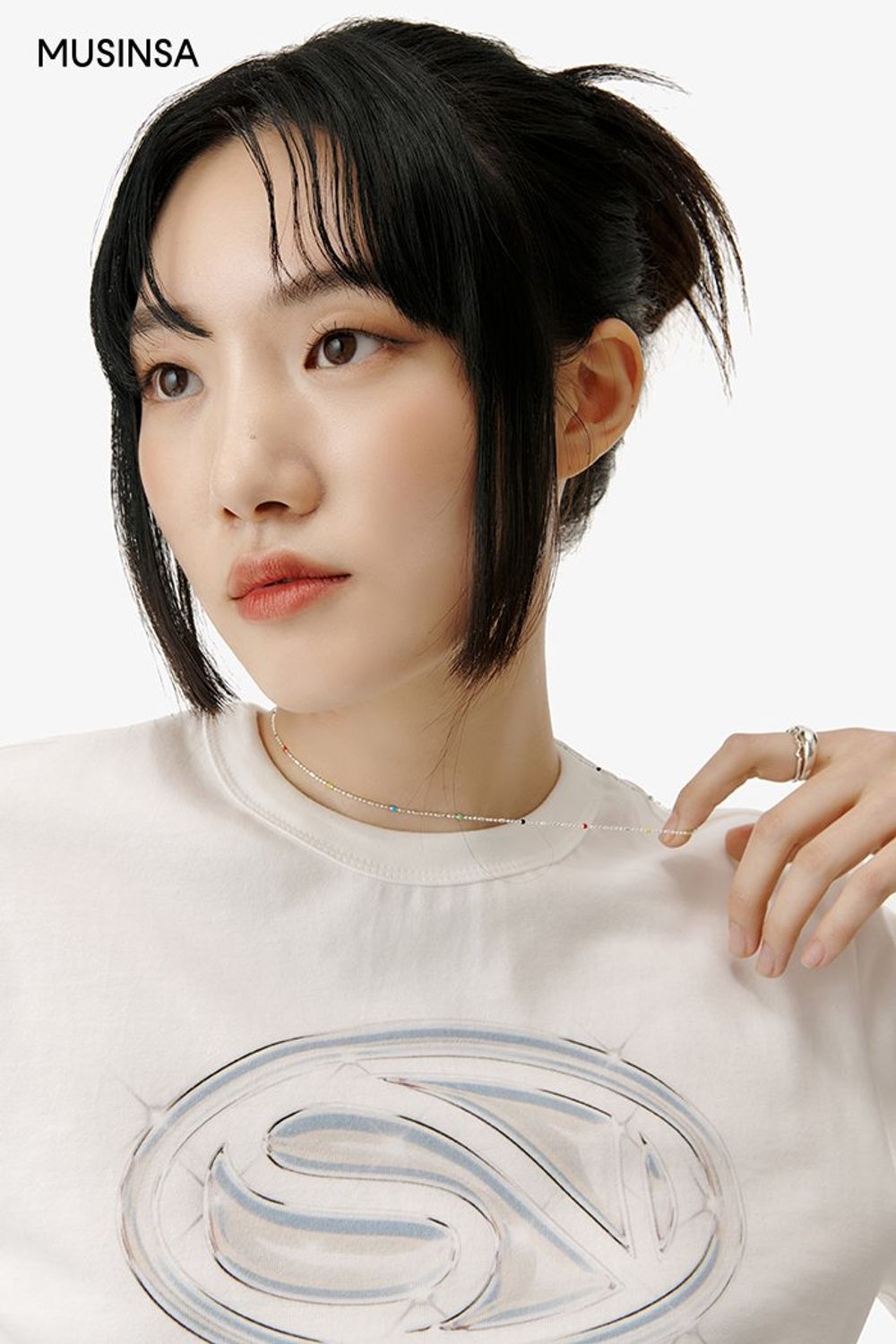 그래픽이 돋보이는 티셔츠와 카고 팬츠를 함께 입고 실버 컬러 미니 백으로 포인트를 더한 캐주얼 룩 #심볼 #와이드핏 #올화이트 #메탈릭 #크롭 #여름 #캐주얼 #실버백 #에디터_이민영